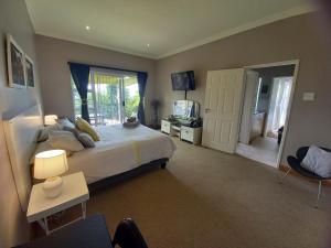 - une chambre avec un grand lit et une télévision dans l'établissement Terryton Country Estate, à Gonubie