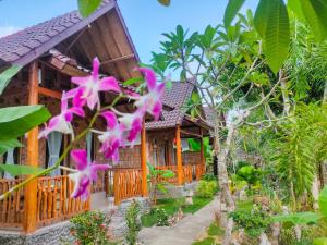a house with pink flowers in front of it at Grealeen Cottages in Nusa Penida