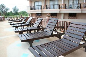 a row of wooden benches sitting on a balcony at Sunview Place in Pattaya Central