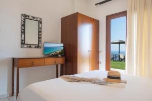 1 dormitorio con cama, espejo y ventana en Aegean Blue Horizon, en Afitos