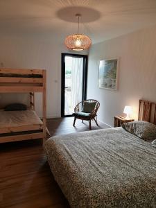 a bedroom with two bunk beds and a chandelier at Villa des Dunes in Gouville-sur-Mer