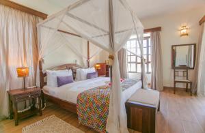 A bed or beds in a room at Mzima Beach Residences - Diani Beach