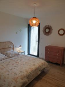 ein Schlafzimmer mit großem Bett und Fenster in der Unterkunft Maison Les Dunes Bourgales in Gouville-sur-Mer + 8 Fotos