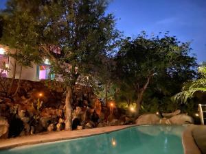 une foule de gens debout autour d'une piscine la nuit dans l'établissement The Wild Blue Lodge SAFARI & SPA, à Hoedspruit