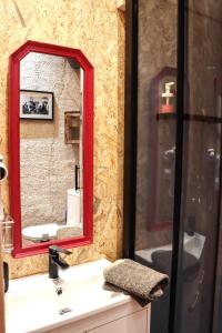 a bathroom with a red mirror and a sink at Le Moulin de Chamambard in Saint-Denis-lès-Bourg