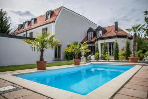 a swimming pool in front of a house at Hotel Domizil in Ingolstadt