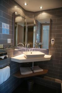a bathroom with a sink and a mirror at Holiday Inn Express Zürich Airport, an IHG Hotel in Rümlang