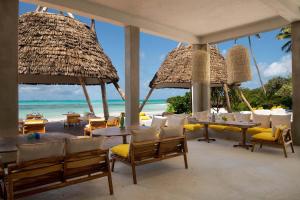a restaurant on the beach with tables and chairs at Upendo Beach Boutique Hotel Zanzibar in Michamvi