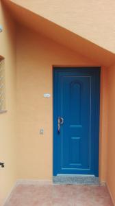 una puerta azul en el lateral de un edificio en casa sa ide, en Torre dei Corsari