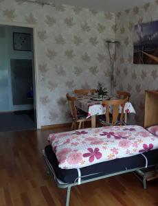 - une chambre avec un lit, une table et des chaises dans l'établissement Ferienwohnung Panorama, à Bad Peterstal-Griesbach