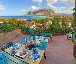 una mesa azul con comida en la parte superior de un patio en Il Glicine sul Golfo, en Mondello