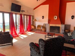 a living room with red walls and a fireplace at Estalagem Abrigo da Montanha in Monchique