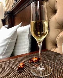 a glass of white wine sitting on a table at Picasso Boutique Hotel in Arad