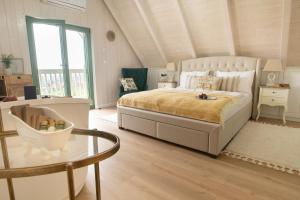 1 dormitorio con 1 cama grande y 1 mesa en Lovassy Lodge Vendégház en Lovas