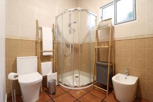 a bathroom with a shower and a toilet and a sink at Janela Mar Garden in Lagoa +55 photos