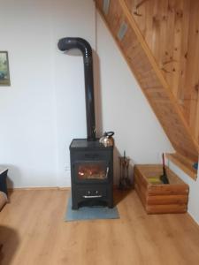 a wood stove in a room with a staircase at APARTMANI Arsic in Jahorina