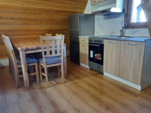 uma cozinha com uma mesa, cadeiras e um fogão em APARTMANI Arsic em Jahorina