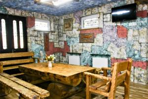 Habitación con mesa de madera y pared de piedra. en Mango's Guesthouse en Kutaisi