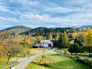 a town with a road and trees in the background at Apartamenty Riders Lodge Szczyrk Kalinowa in Szczyrk