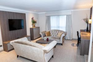 uma sala de estar com dois sofás e uma televisão em Seagoe Hotel em Portadown