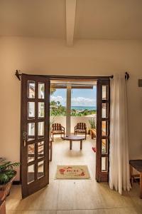 una puerta abierta a un patio con vistas al océano en Apartamentos Quintal - 2 Quartos Suítes e Sala, en Morro de São Paulo