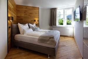 ein Schlafzimmer mit einem großen Bett und einer Holzwand in der Unterkunft Villa Mama - Luxus und Lebensfreude in Seefeld in Tirol
