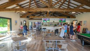 a group of people standing in a room with ping pong tables at CAMPING AZU'RIVAGE in Azur