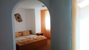um quarto com uma cama e uma porta arqueada em Guest House Malkata Stopanka em Primorsko