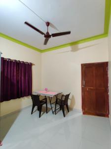 mesa y sillas en una habitación con ventilador de techo en Shree Hari Guest House, en Anjuna