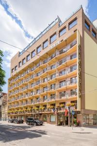 un gran edificio con coches estacionados frente a él en Eurohotel, en Leópolis