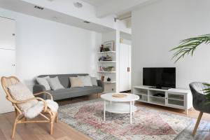 a living room with a couch and a tv at 2ndhomes Loft Apartment with Spa & Balcony by the White Church in Helsinki