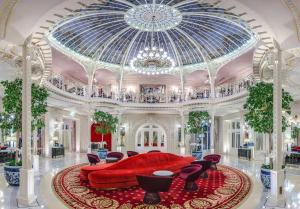 a large living room with a red couch and a glass ceiling at H&ocirc;tel Hermitage Monte-Carlo in Monte Carlo