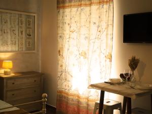 una finestra con tenda e tavolo con bicchieri da vino di Casine Calasole a Torino