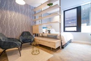 a bedroom with a bed and a desk and two chairs at #AlimamaSpaces The Foreshore Haven in Cape Town