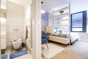 a bathroom with a bed and a toilet in a room at #AlimamaSpaces The Foreshore Haven in Cape Town +15 photos