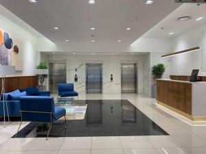 a lobby with blue chairs and a reception desk at #AlimamaSpaces The Foreshore Haven in Cape Town