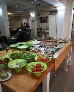 une table avec de nombreuses assiettes de nourriture dans l'établissement Astoria Galilee Hotel, à Tibériade