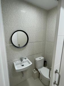 a bathroom with a sink and a toilet and a mirror at Apartamento frente a la playa Piso 3 in Estepona