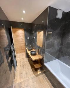a bathroom with a sink and a bath tub at Les Balcons de Valloire in Valloire
