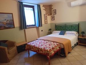a bedroom with a bed and a chair and a window at B&B Renzano bedrooms in Salò