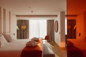 een hotelkamer met een bed met handdoeken erop bij Lumen Hotel & The Lisbon Light Show in Lissabon