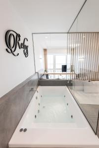 een bad in een badkamer met een bord aan de muur bij Porto Sea View Apartments - Luxury Junior Suites in Thessaloniki