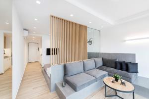 ein Wohnzimmer mit einem Sofa und einem Tisch in der Unterkunft Porto Sea View Apartments - Luxury Junior Suites in Thessaloniki