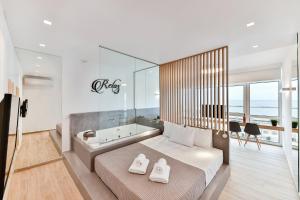 1 Schlafzimmer mit einer Badewanne und 1 Bett mit 2 Handtüchern in der Unterkunft Porto Sea View Apartments - Luxury Junior Suites in Thessaloniki