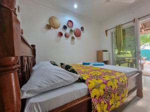 a bedroom with a bed with a colorful comforter at Tamaru House Bungalow with Patio in Nungwi