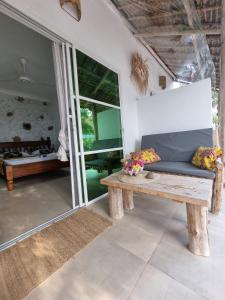una sala de estar con un banco de madera y una mesa. en Tamaru House Bungalow with Patio, en Nungwi