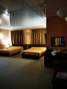 ネフテカムスクにあるОтель "ОСКАР"のベッド2台とテレビが備わるホテルルームです。