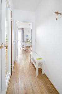 ein weißes Zimmer mit einer Bank und einem Tisch in der Unterkunft Ferienwohnung Kleine Luise in Norderney