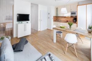 eine Küche und ein Wohnzimmer mit einem Tisch und Stühlen in der Unterkunft Ferienwohnung Kleine Luise in Norderney