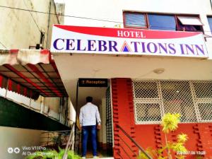 un hombre parado en la puerta de un hotel en Celebrations Inn Pune, en Pune